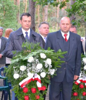 Burmistrz Paweł Bednarczyk i Wiceburmistrz Waldemar Banaszek składają kwiaty przy pomniku straceń w lesie na Konarach (fot. UM w Tłuszczu)